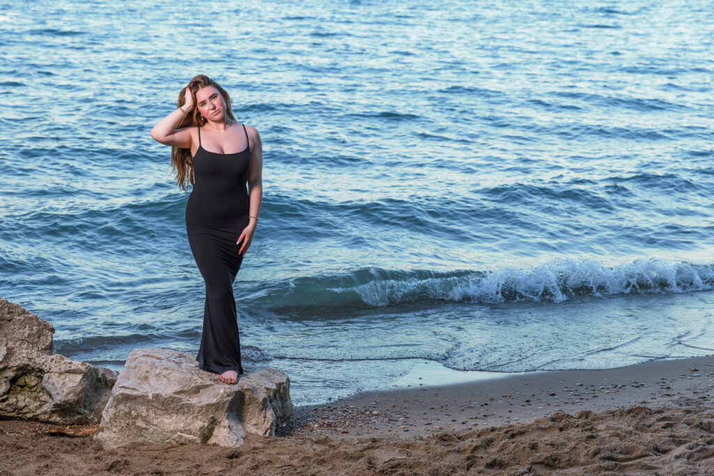 A girl on the beach in a black gown.